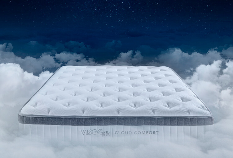 Image of mattress floating on white clouds against blue sky